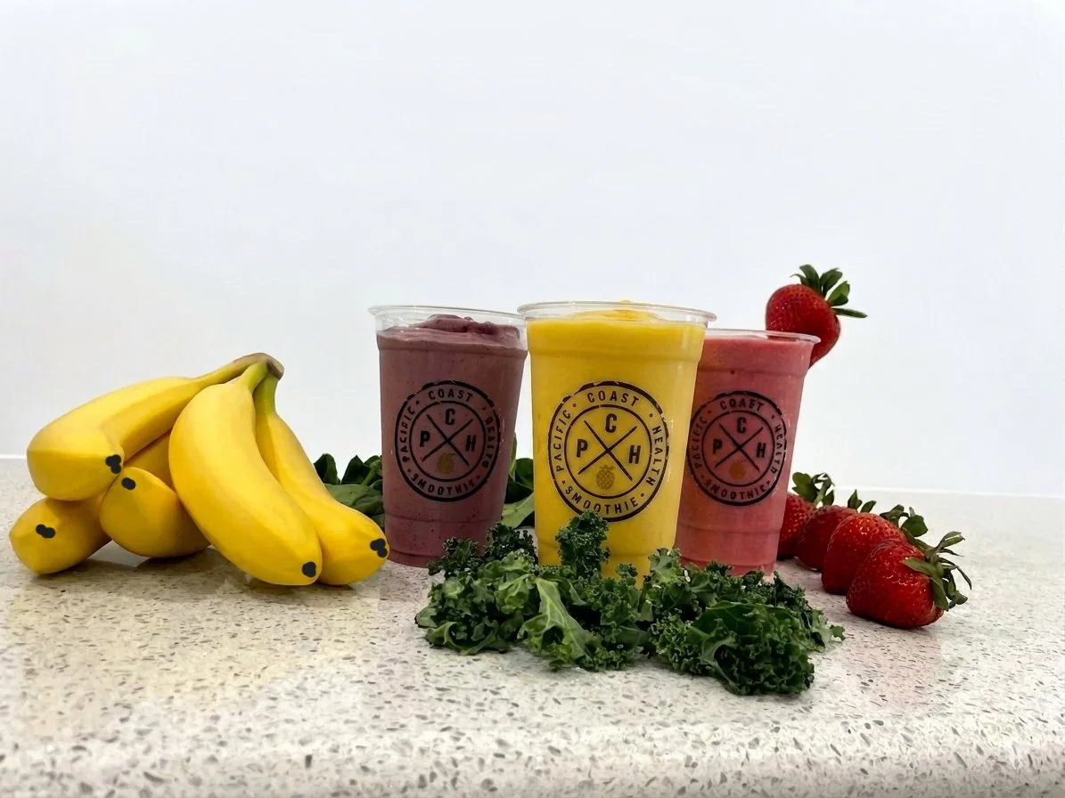 Three Pacific Coast Health Smoothie cups with fresh fruit and kale
